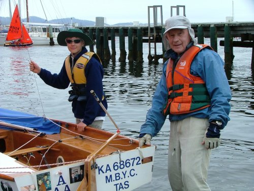 A gentleman holding his floating Mirror dinghy near the transom before launching with his younger crew